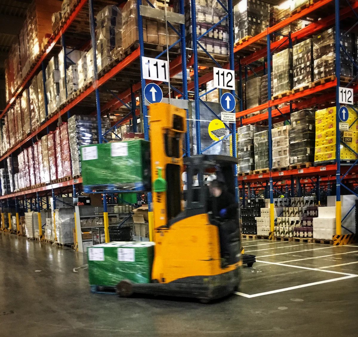 Chariot élévateur dans une allée d'entrepôt logistique