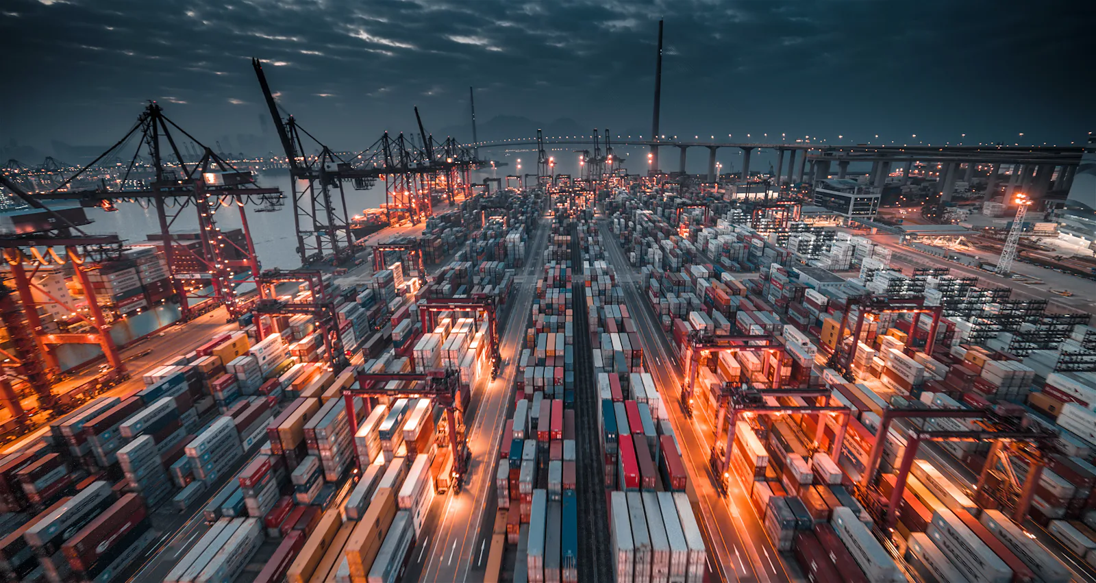 Vue aérienne d'un port à conteneurs éclairé à la tombée de la nuit